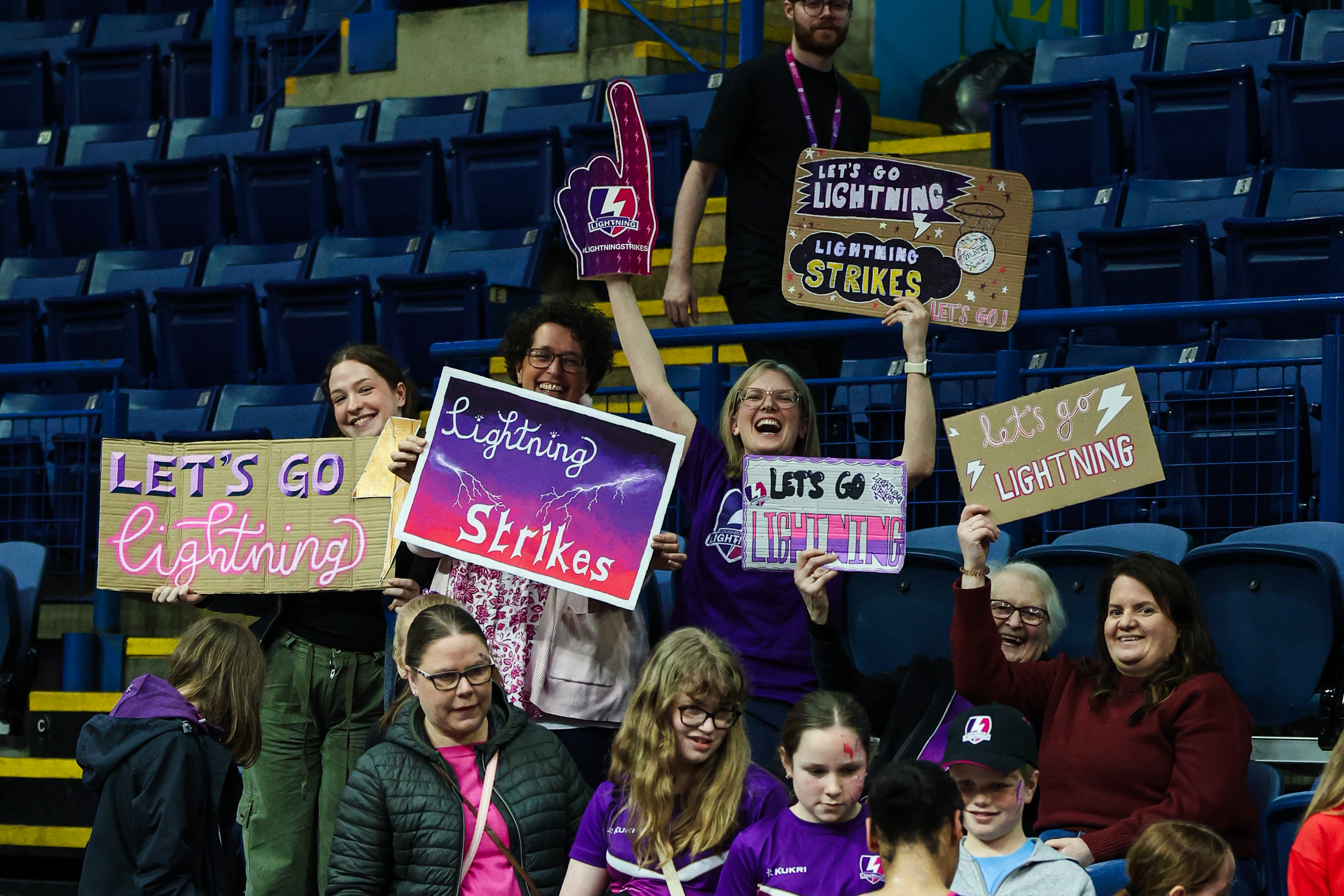 a group of women with signs supporting loughborough lightning